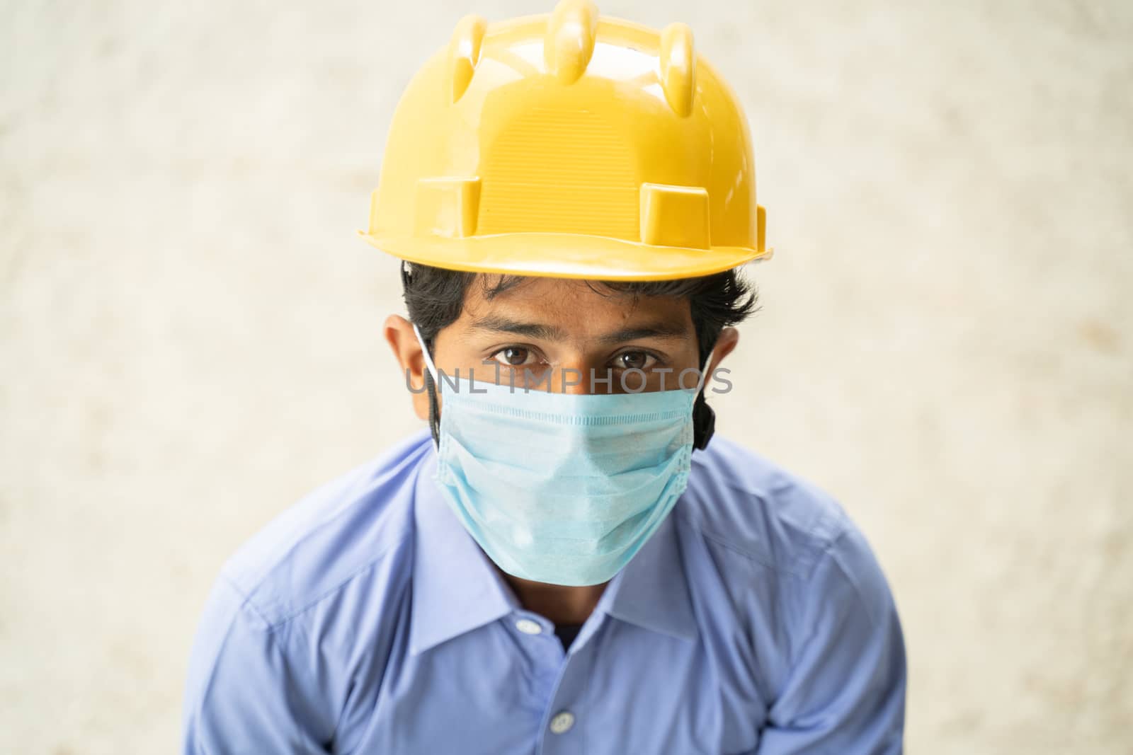 Hing angle view of Construction worker in medical mask looking up in confident - concept of business, industry reopen and covid-19 safety measures at workplace. by lakshmiprasad.maski@gmai.com