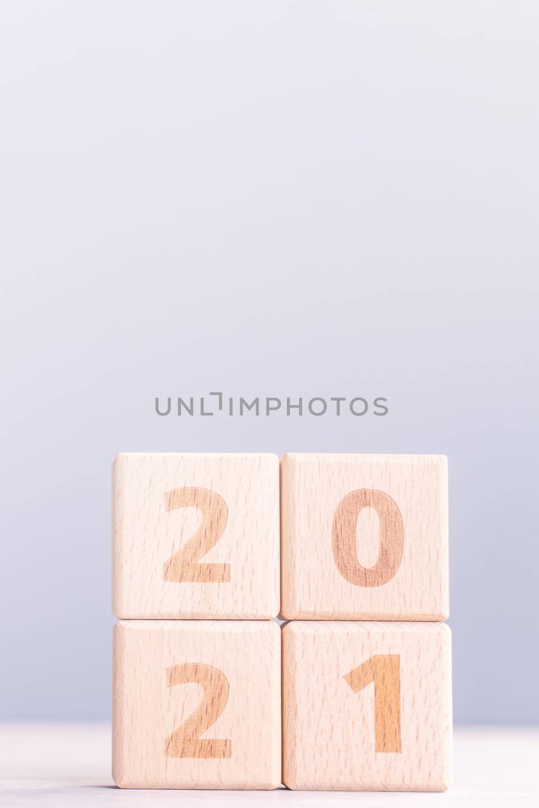 2021 New Year abstract design concept - Number wood block cubes isolated on wooden table and light mist blue background.