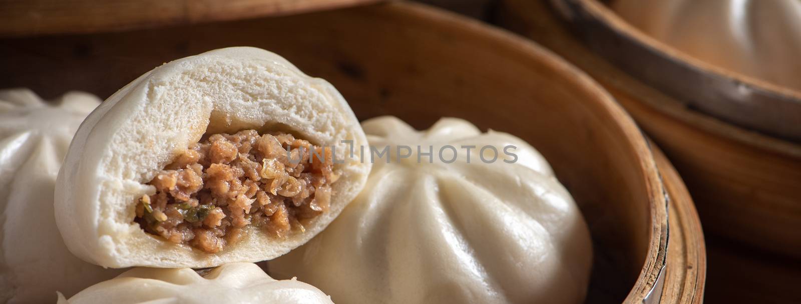 Close up of fresh delicious baozi, Chinese steamed meat bun is ready to eat on serving plate and steamer, close up, copy space product design concept.