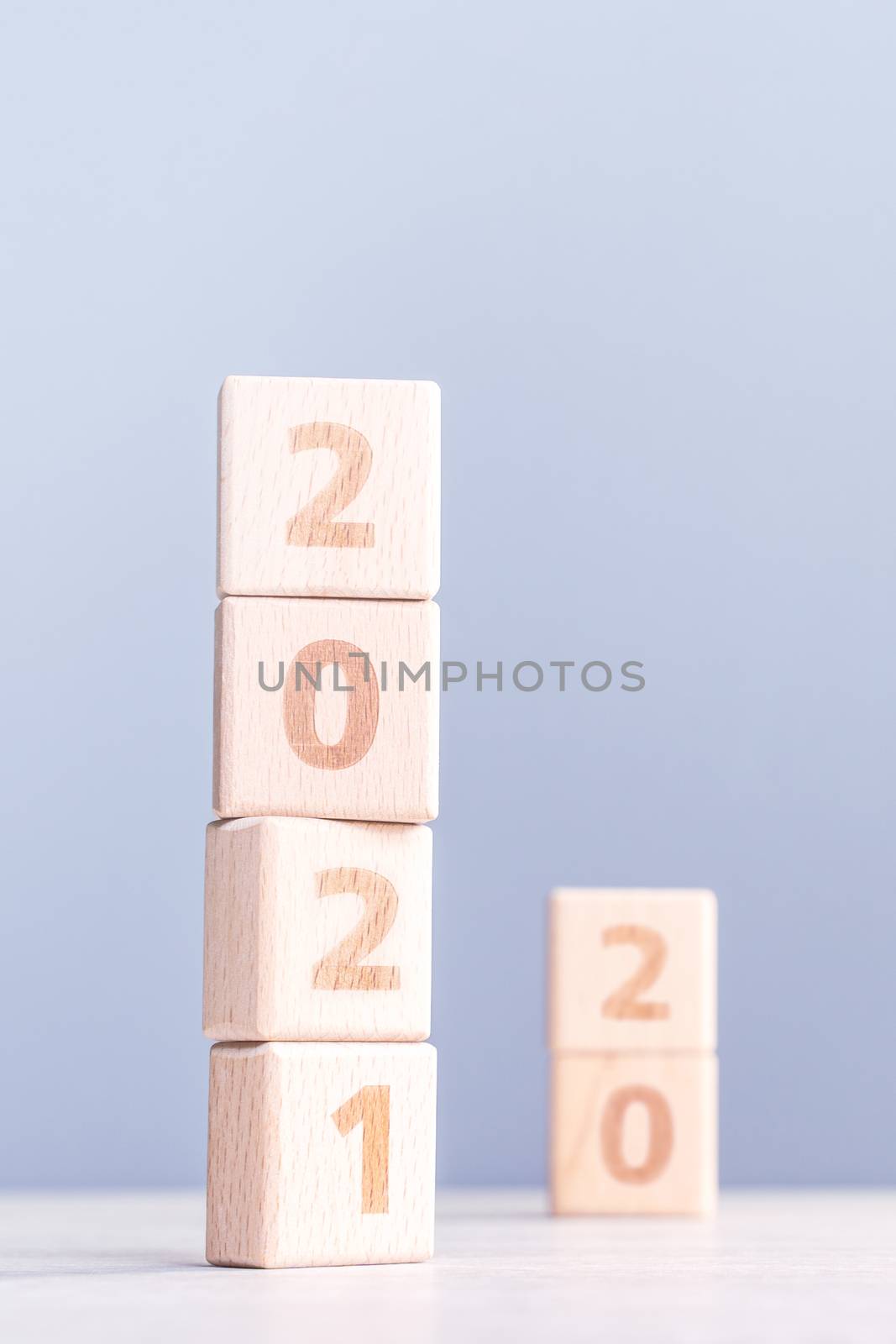 2021 New Year abstract design concept - Number wood block cubes isolated on wooden table and light mist blue background.