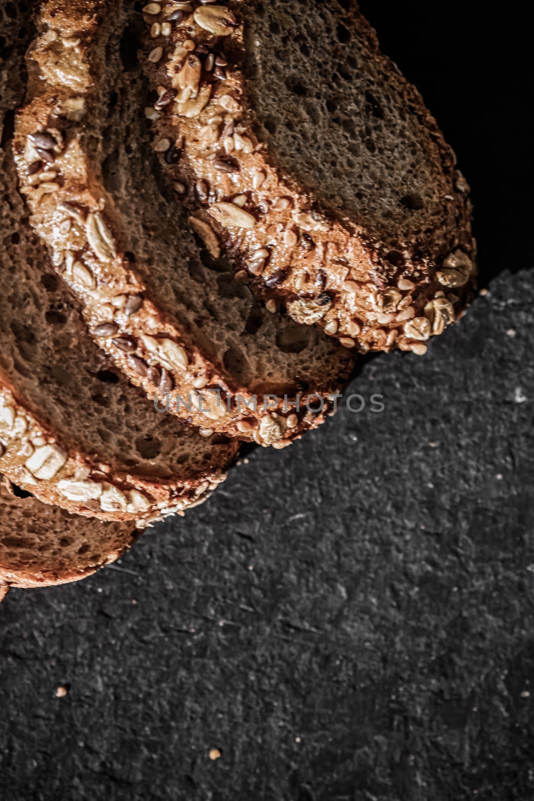 Fresh whole grain seeded bread, organic wheat flour, closeup slice texture as background for food blog or cook book recipes