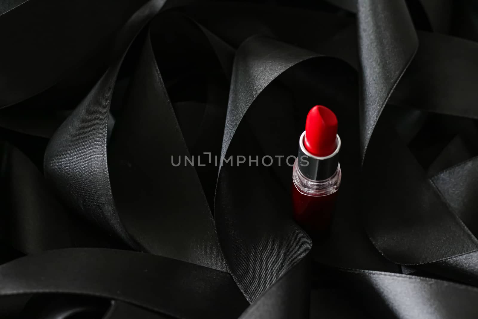 Red lipstick on black silk background, luxury make-up and beauty cosmetics