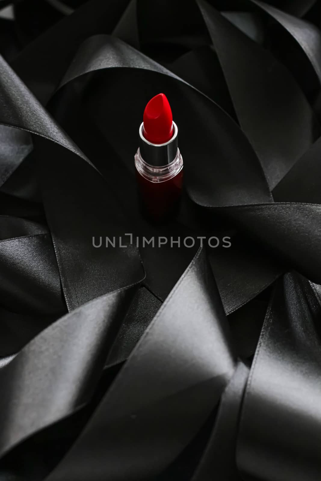 Red lipstick on black silk background, luxury make-up and beauty cosmetics