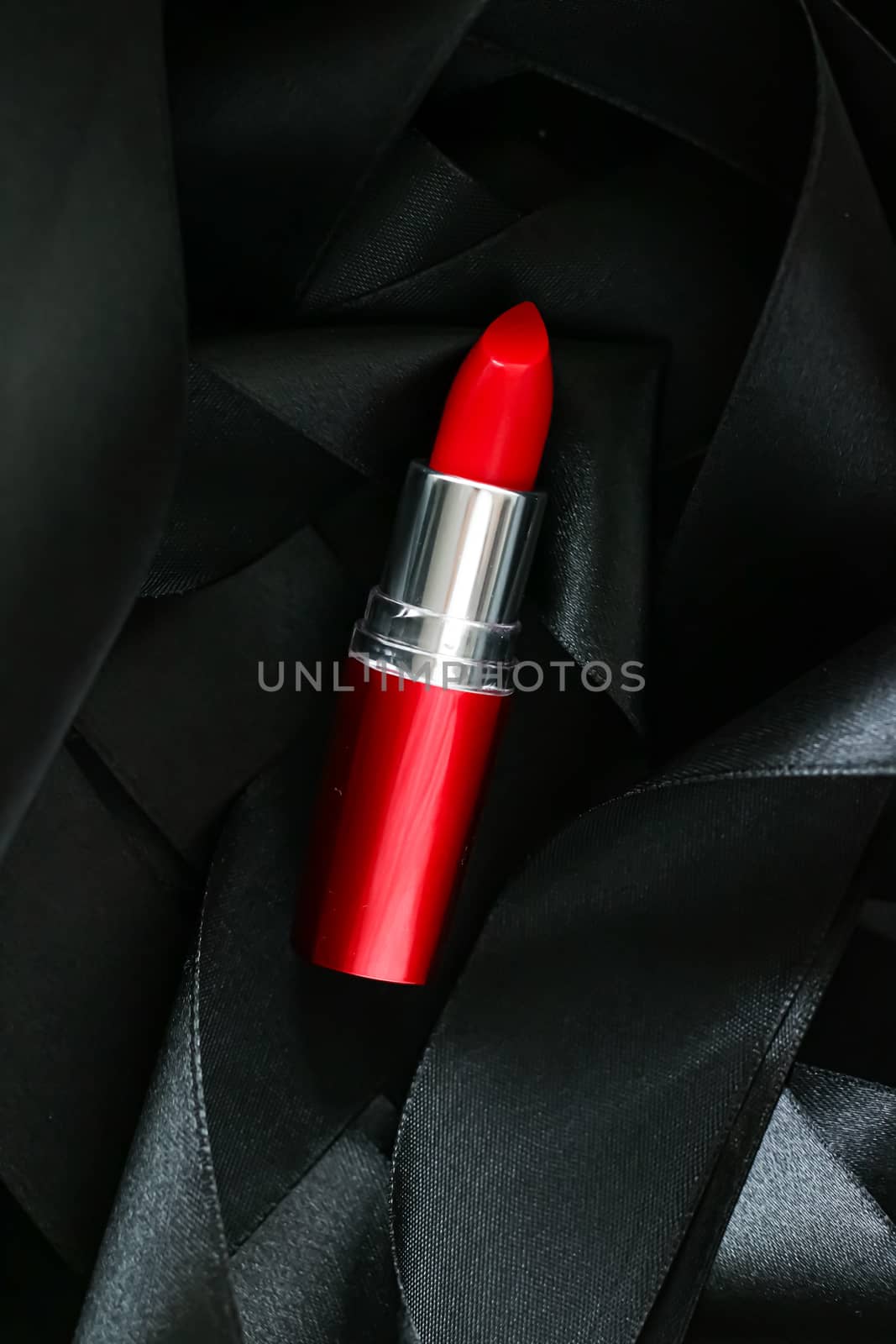 Red lipstick on black silk background, luxury make-up and beauty cosmetics