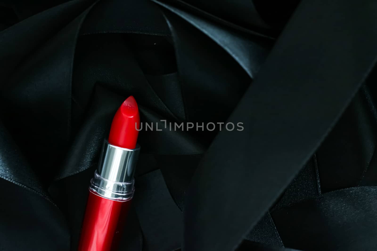 Red lipstick on black silk background, luxury make-up and beauty cosmetics