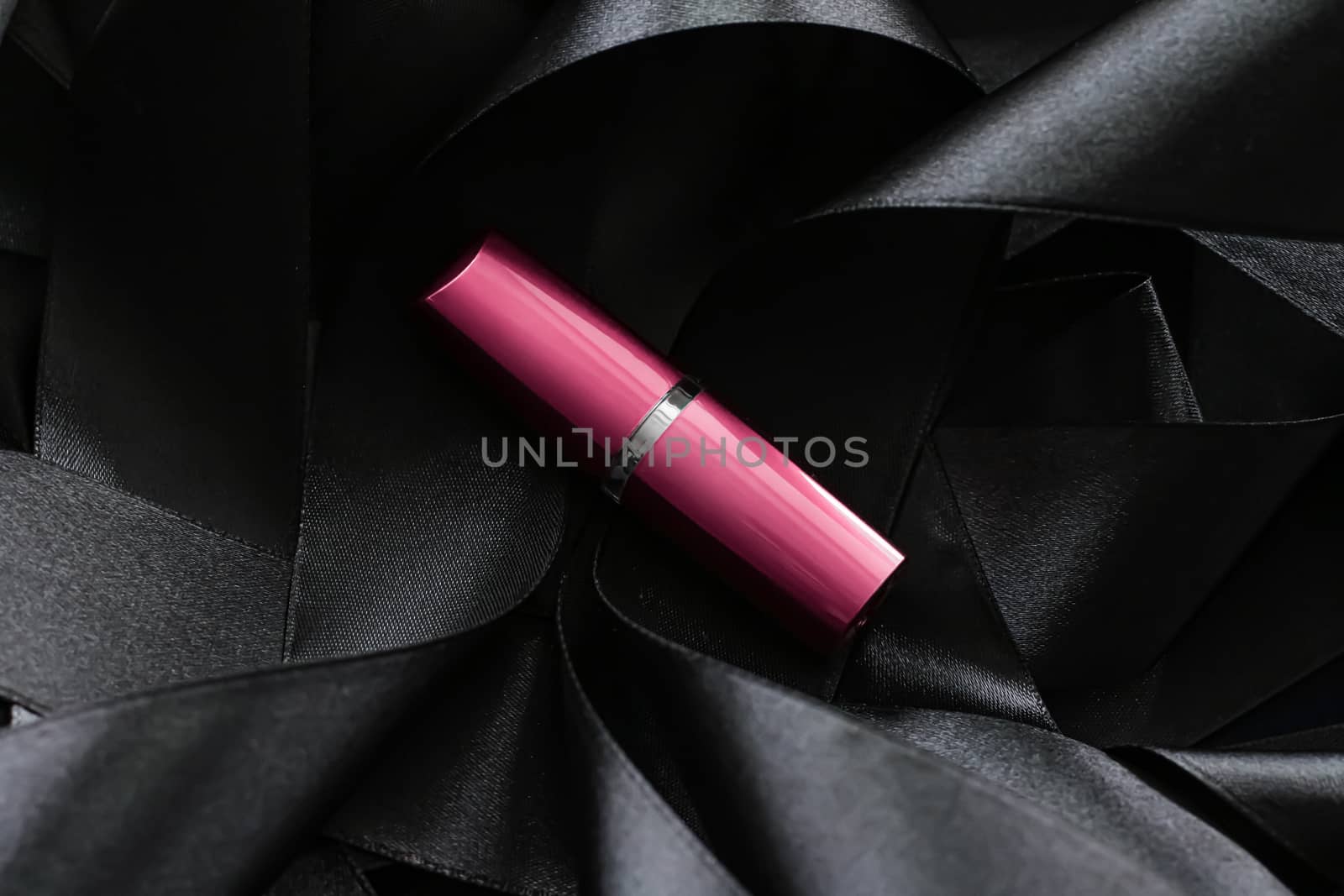 Pink lipstick on black silk background, luxury make-up and beauty cosmetics