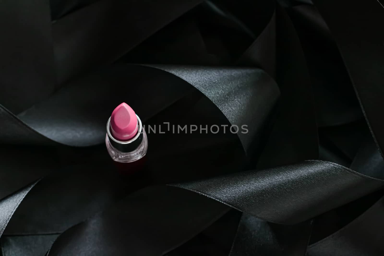 Pink lipstick on black silk background, luxury make-up and beauty cosmetics