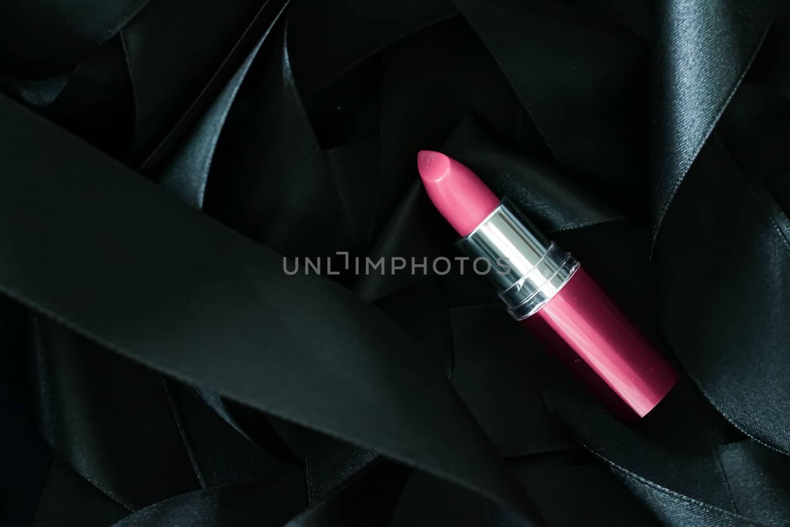 Pink lipstick on black silk background, luxury make-up and beauty cosmetics