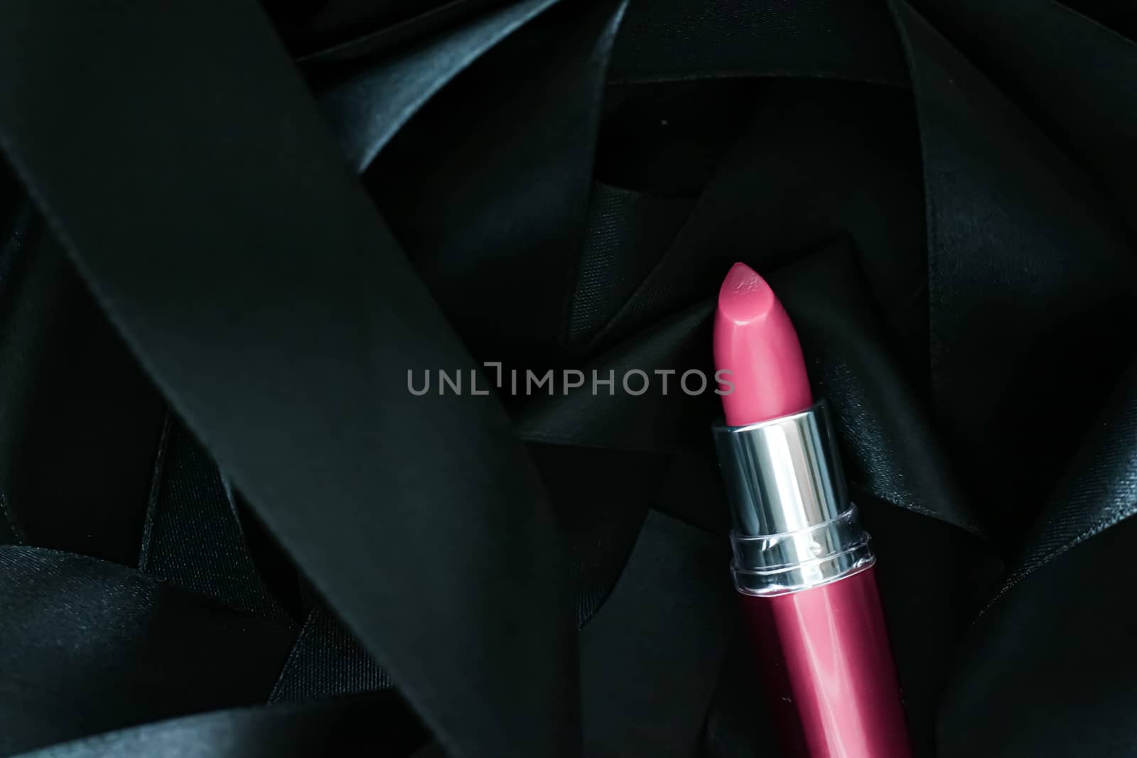 Pink lipstick on black silk background, luxury make-up and beaut by Anneleven