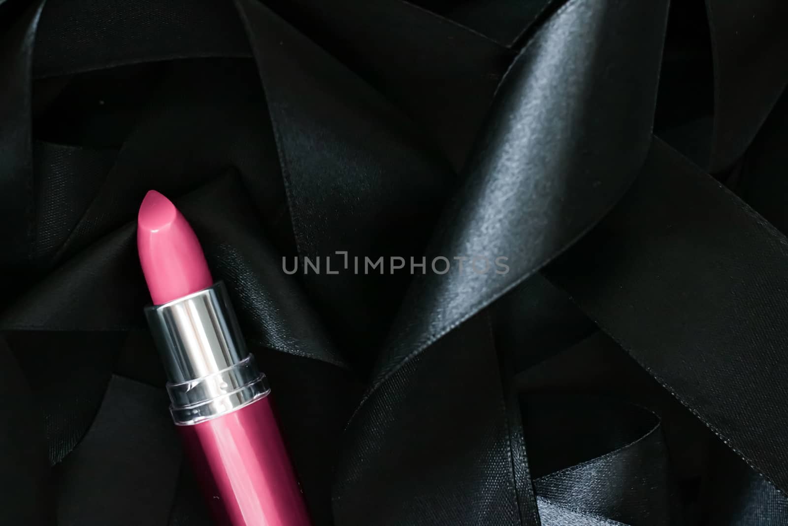 Pink lipstick on black silk background, luxury make-up and beaut by Anneleven