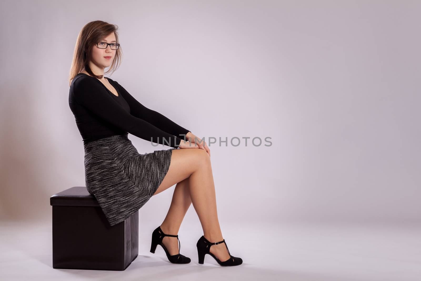 A young girl is sitting on a stool