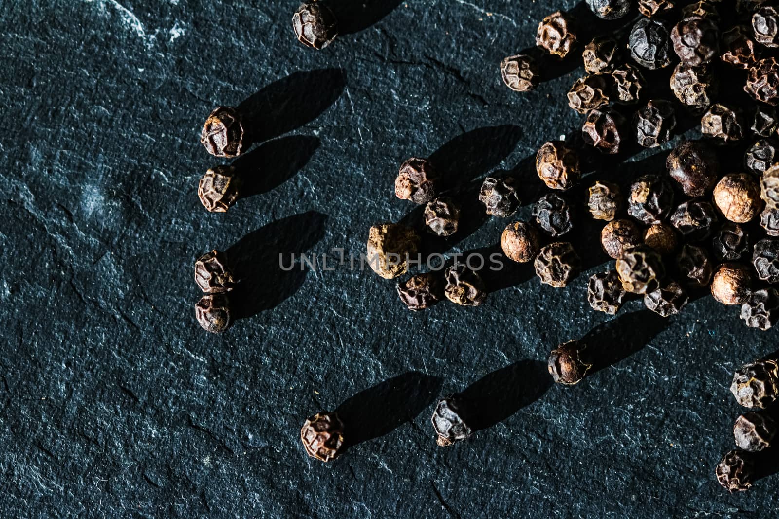 Black pepper closeup on luxury stone background as flat lay, dry by Anneleven