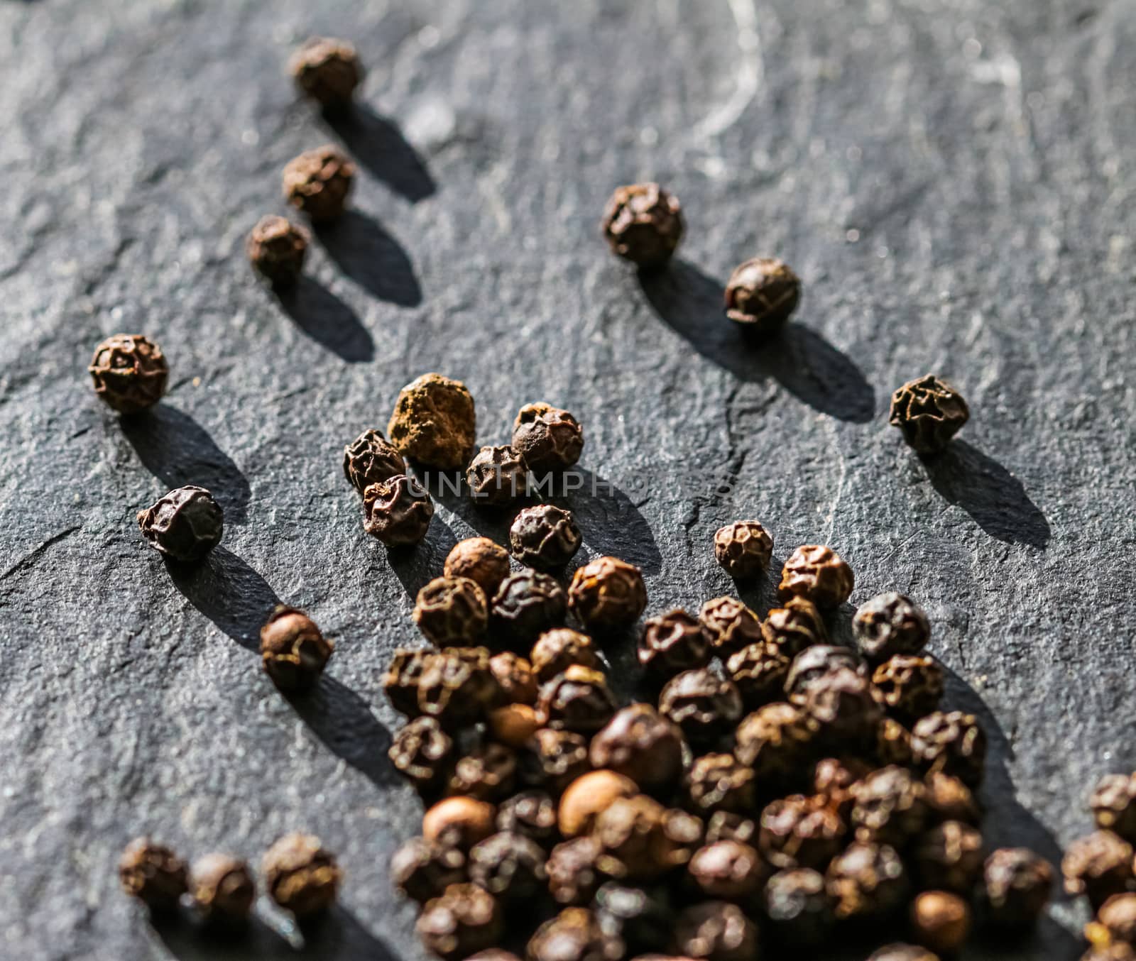 Black pepper closeup on luxury stone background as flat lay, dry food spices and recipe ingredients