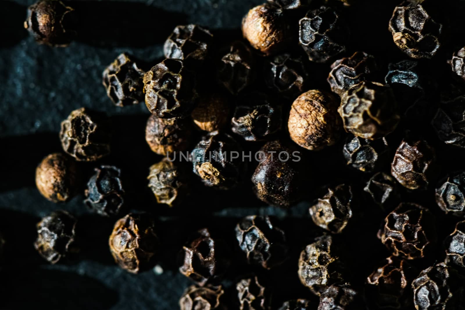 Black pepper closeup on luxury stone background as flat lay, dry food spices and recipe ingredients