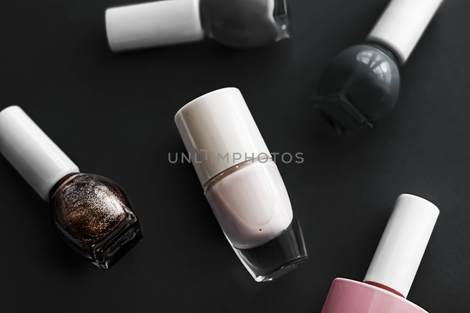 Nail polish bottles on black background, beauty branding