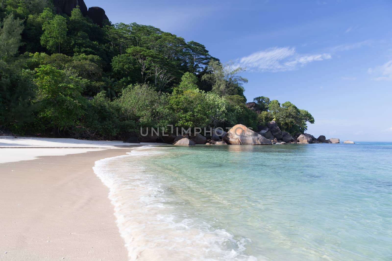 A beach on the Seychelles island with white sand and stones
