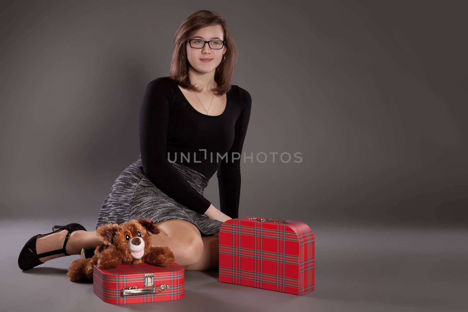A young girl with suitcases and a soft toy