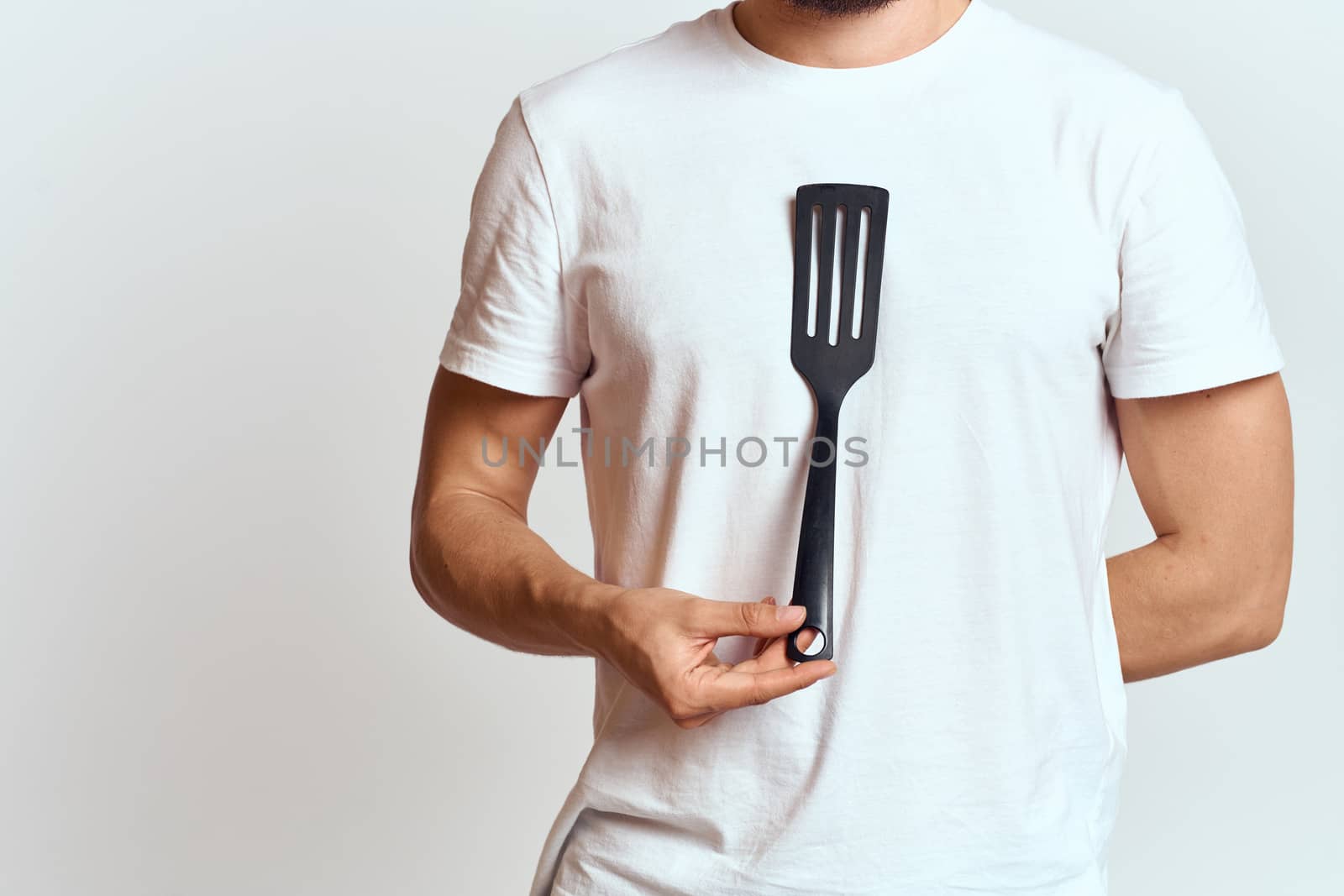 man with shovel for cooking white t-shirt cropped view light background by SHOTPRIME