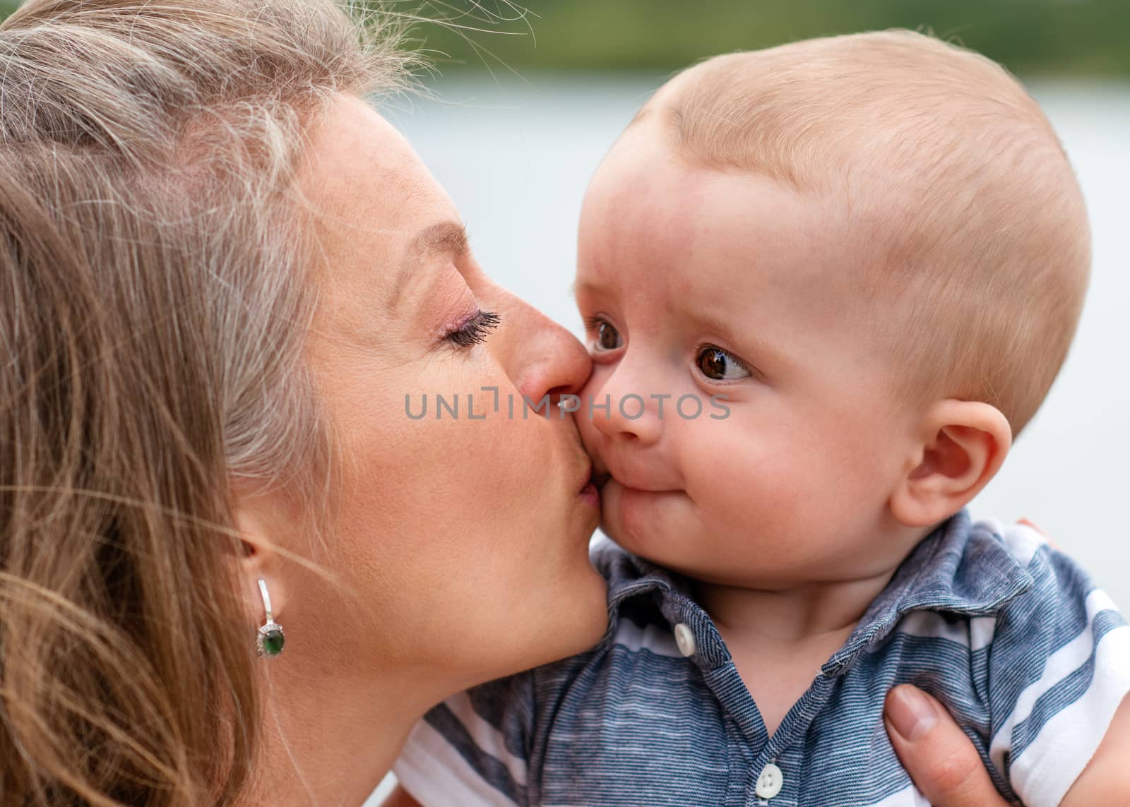 mother holding and kissing son by Iryna_Melnyk