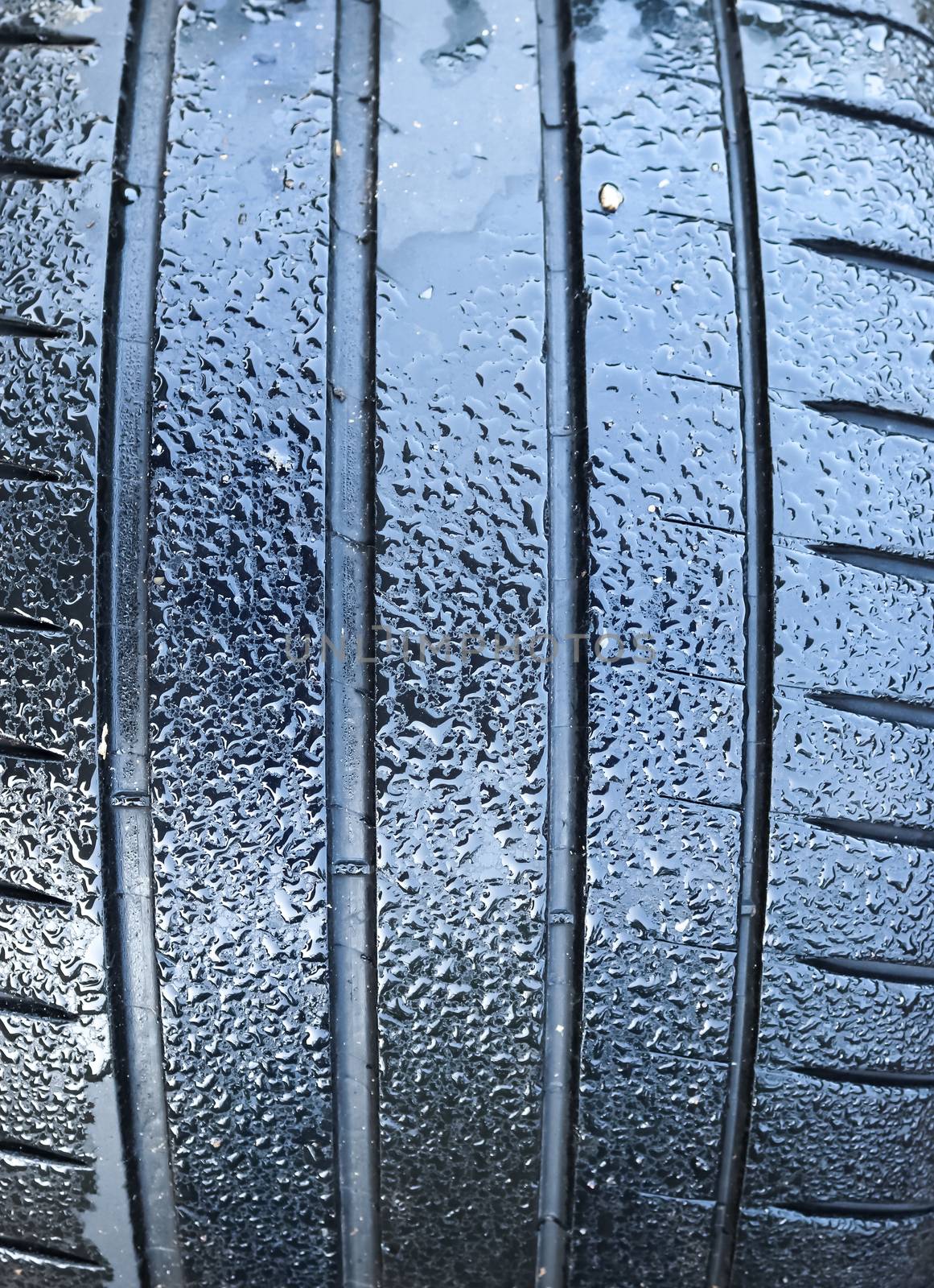 Black big tires in a close up view with water drops. Tire tread  by MP_foto71
