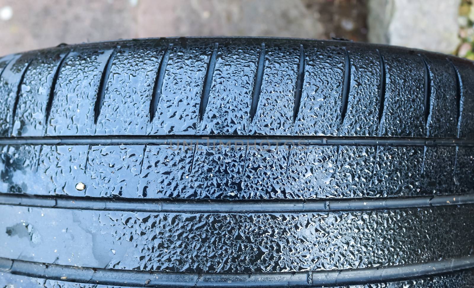 Black big tires in a close up view with water drops. Tire tread  by MP_foto71