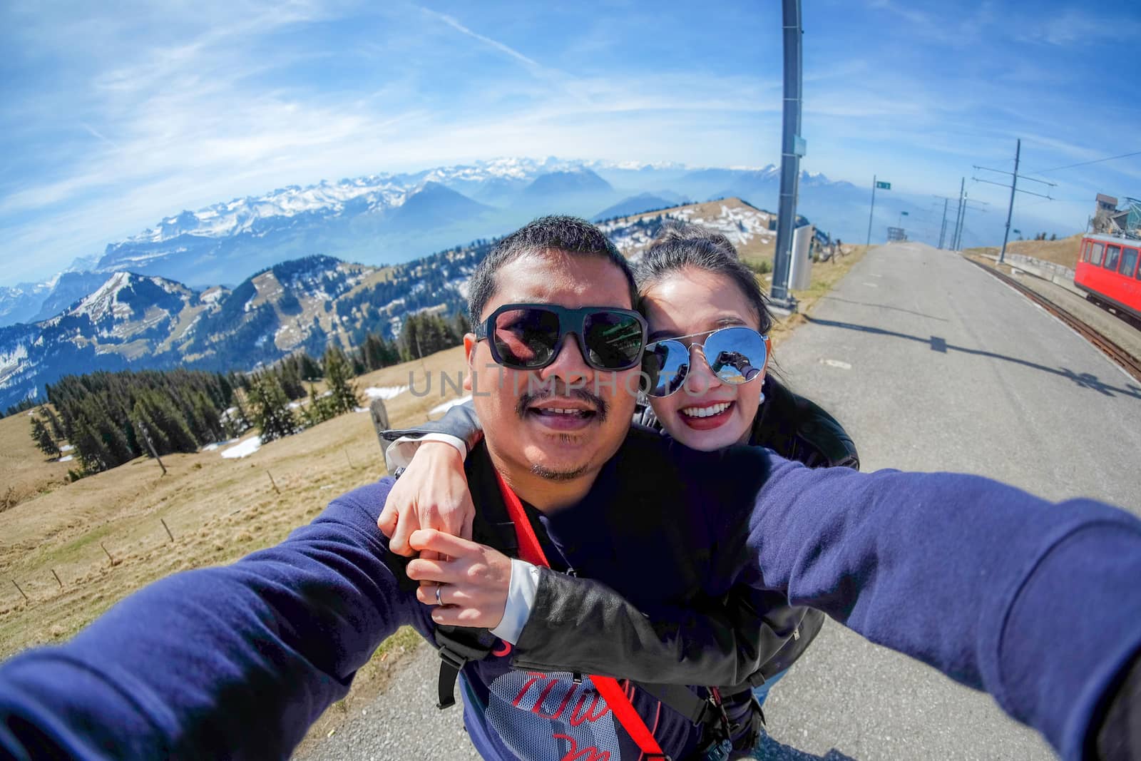 Young Couple Tourists selfie with mobile phone near view of Rigi mountain in Switzerland with a magnificent panoramic view of Swiss alps