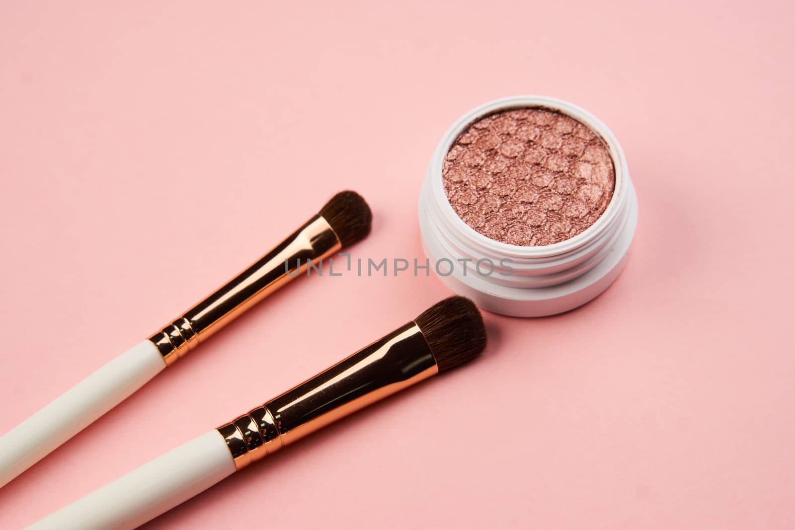 eyeshadow makeup brushes collection professional cosmetics accessories on pink background by SHOTPRIME
