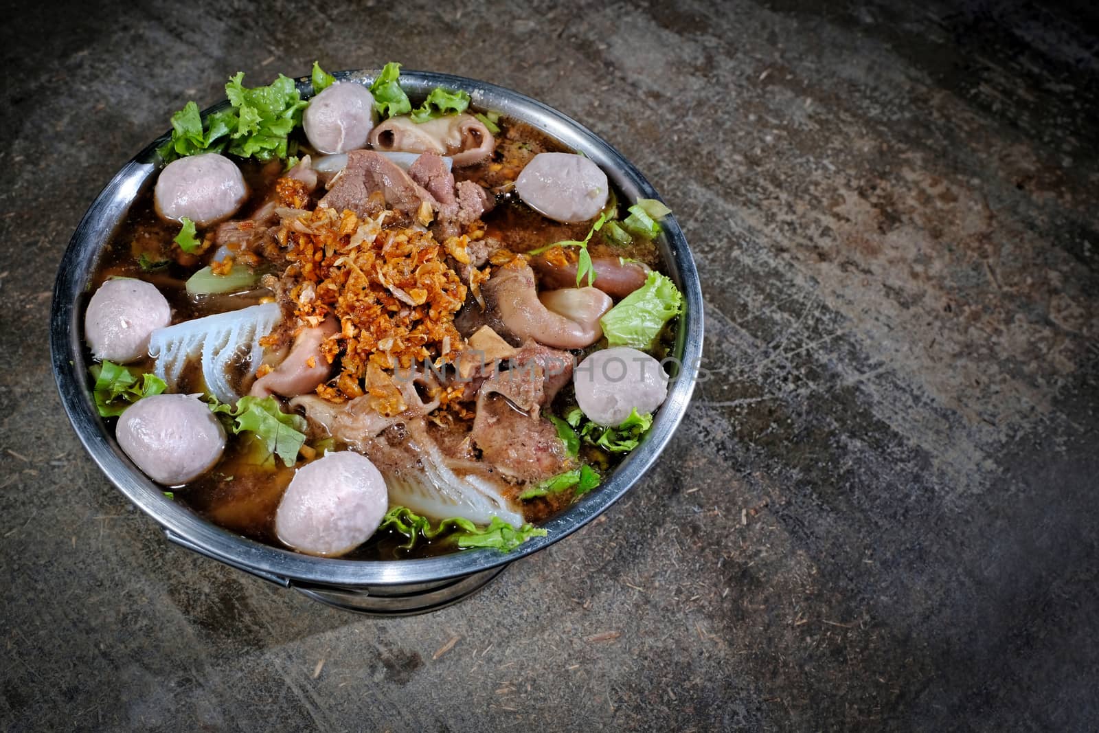 Thai style beef in a hotpot with vegetable on wood background