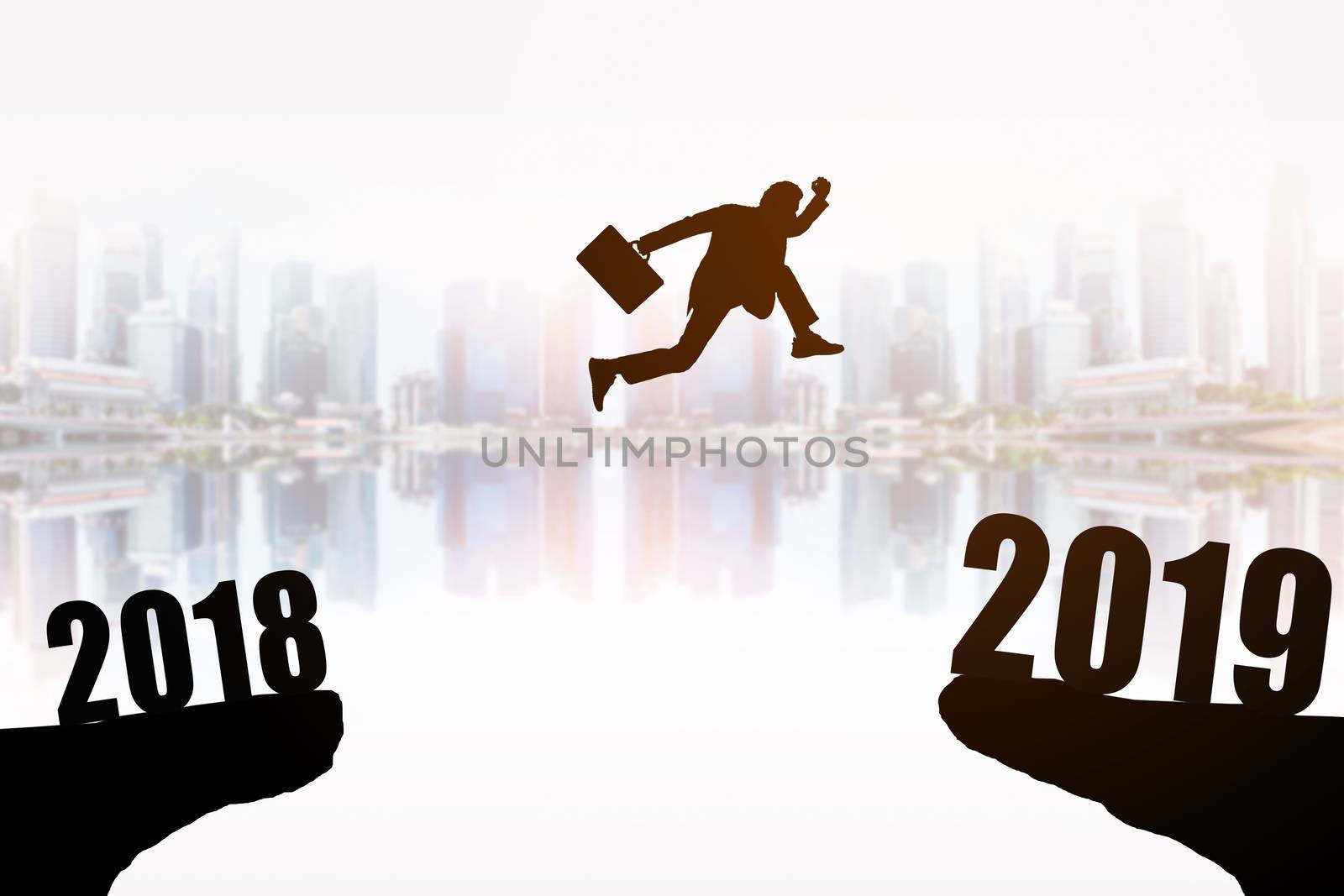 Silhouette of young businessman jumping between 2018 and 2019 years with beautiful the skyscrapers background, concepts of news year and business target.