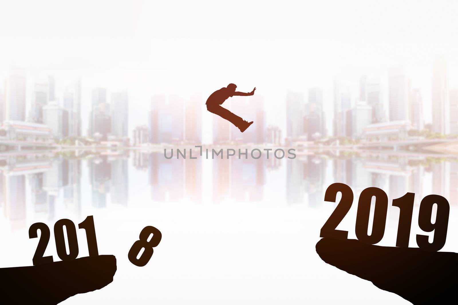 Silhouette of young man jumping between 2018 and 2019 years with beautiful the skyscrapers background, concepts of news year and business target.