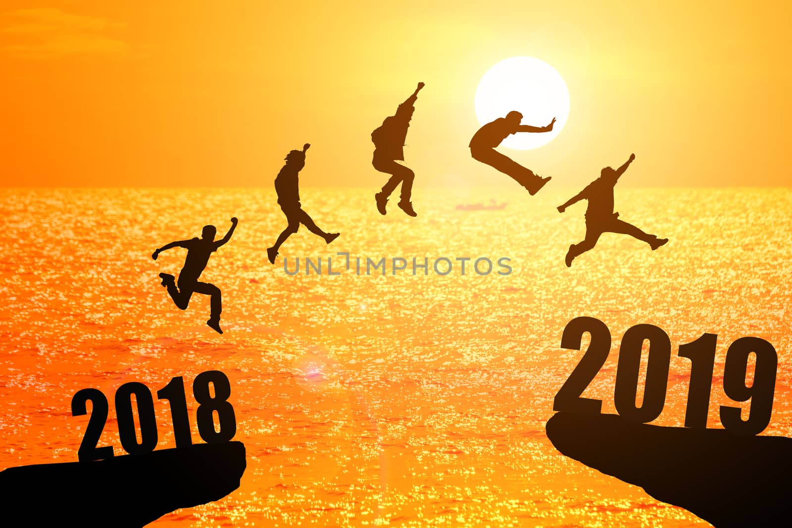 Silhouette group of young mans jumping between 2018 and 2019 years with beautiful sunset at the sea-use for news year and concepts for business and target.