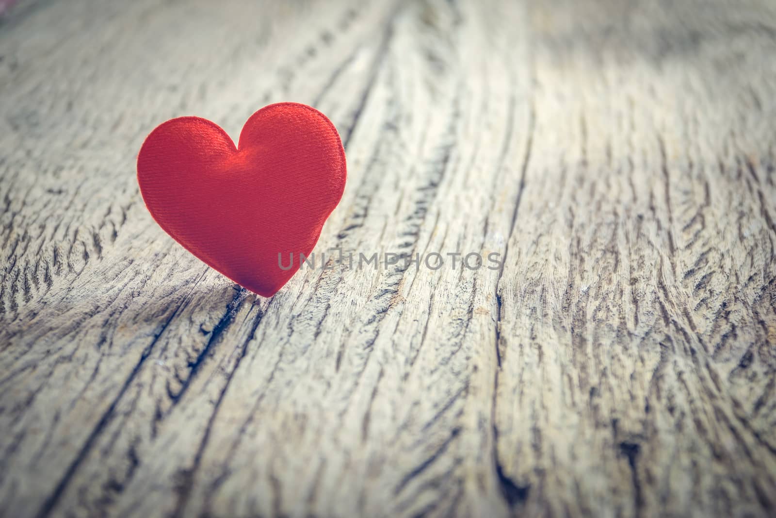 Red heart on wooden floor with copy space for text, used in love concept on Valentine's Day.