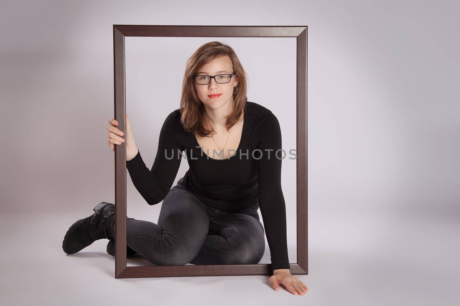 Young woman is sitting on a floor with a picture frame