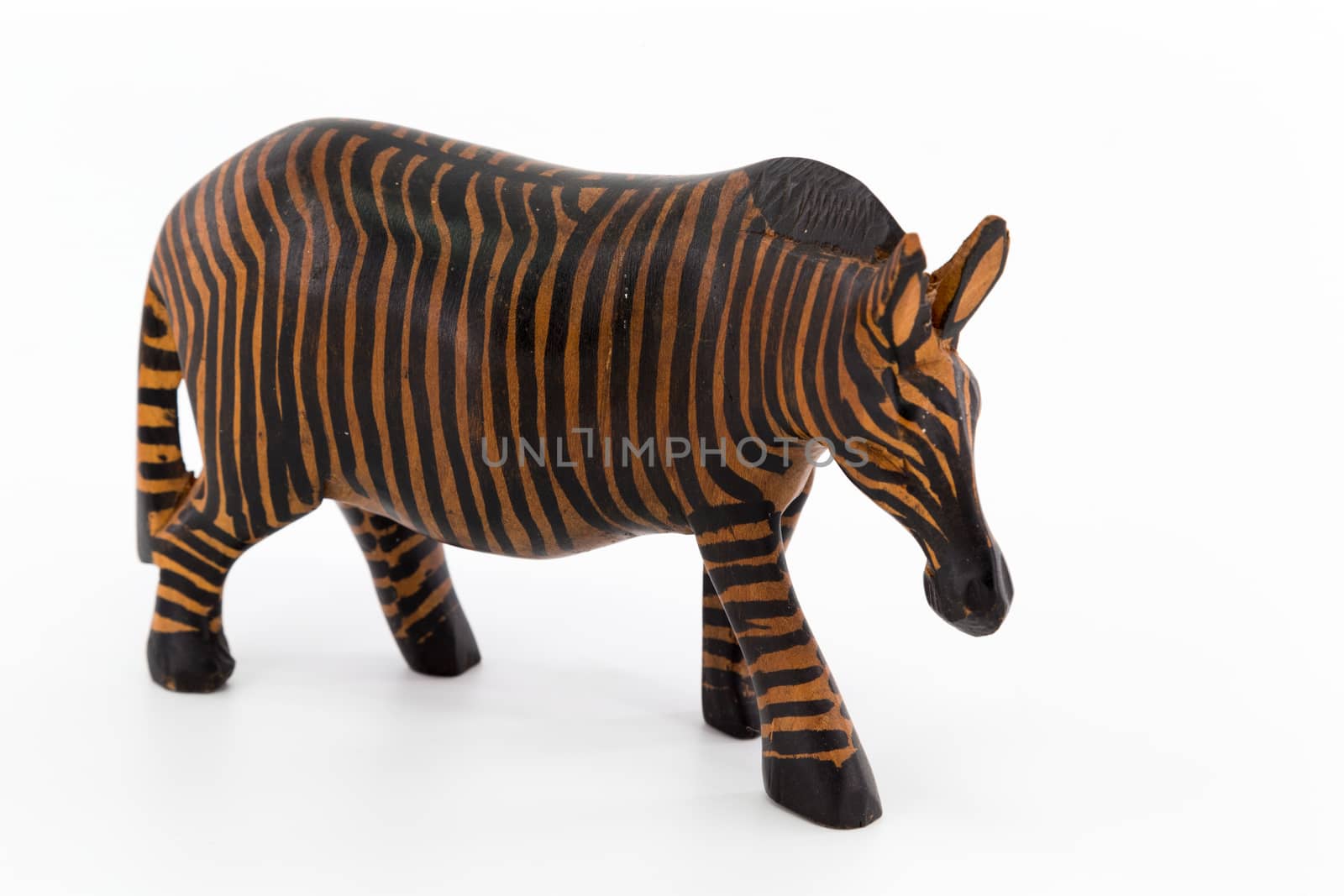 A wooden figure of a zebra on white background