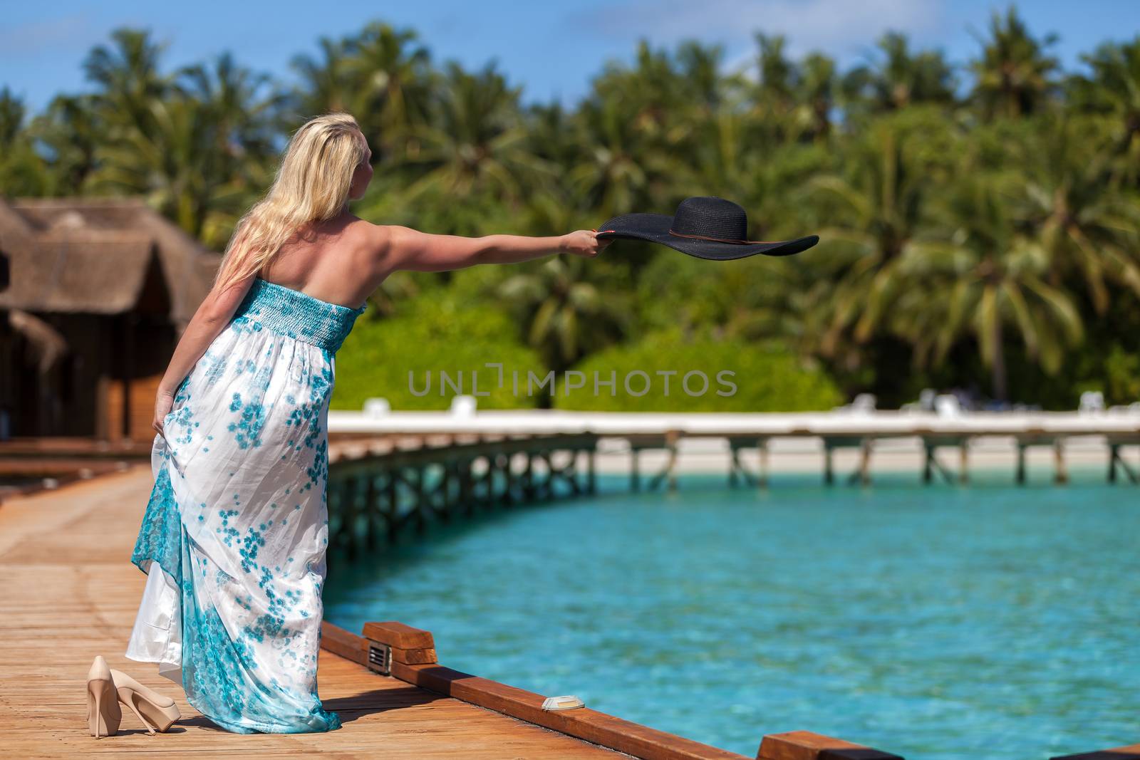 Maldives, Woman throwing her hat into the water