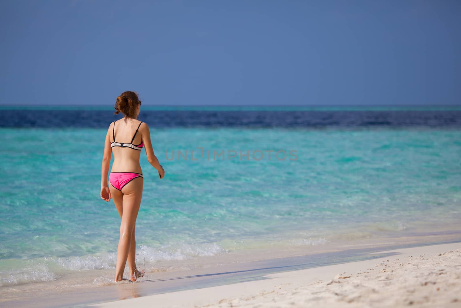 Young woman walking on the beach