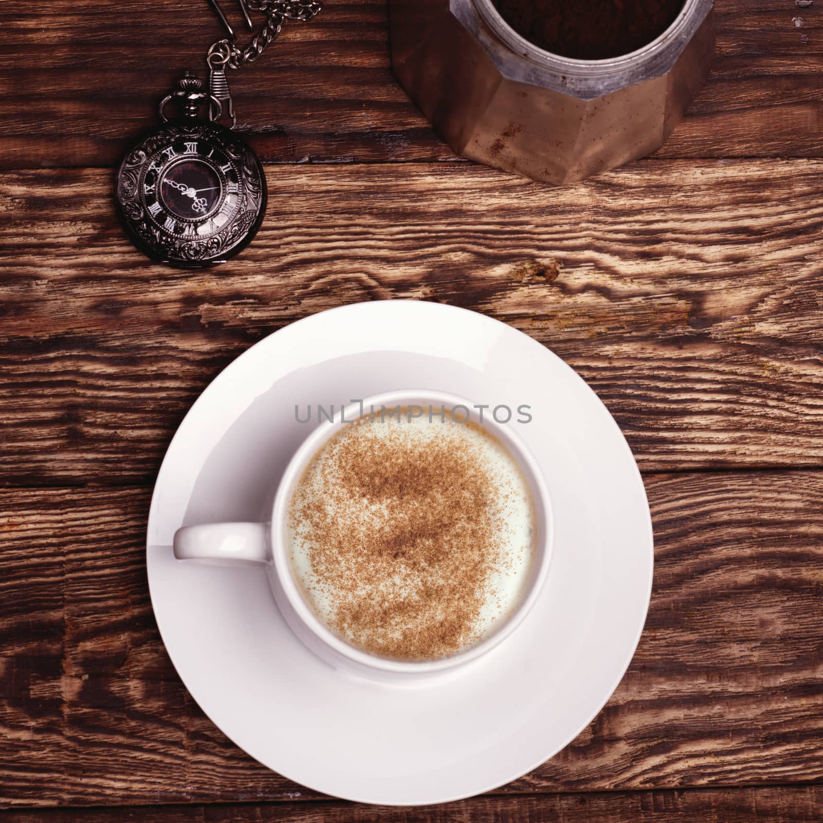Cup of coffee, watch and coffeepot on a wooden background