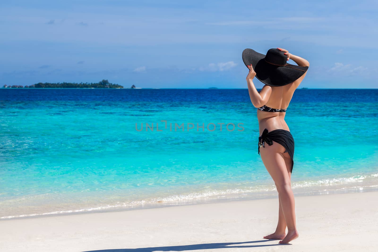 woman is staying on the beach and watching over the sea by 25ehaag6