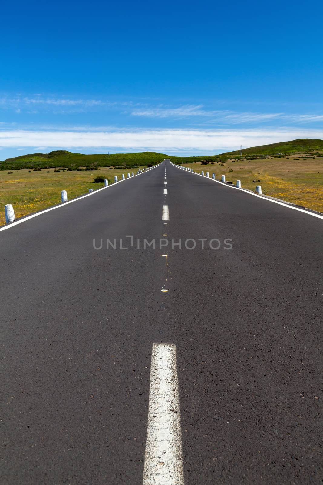 a straight road over the area with a blue sky with any clouds in by 25ehaag6