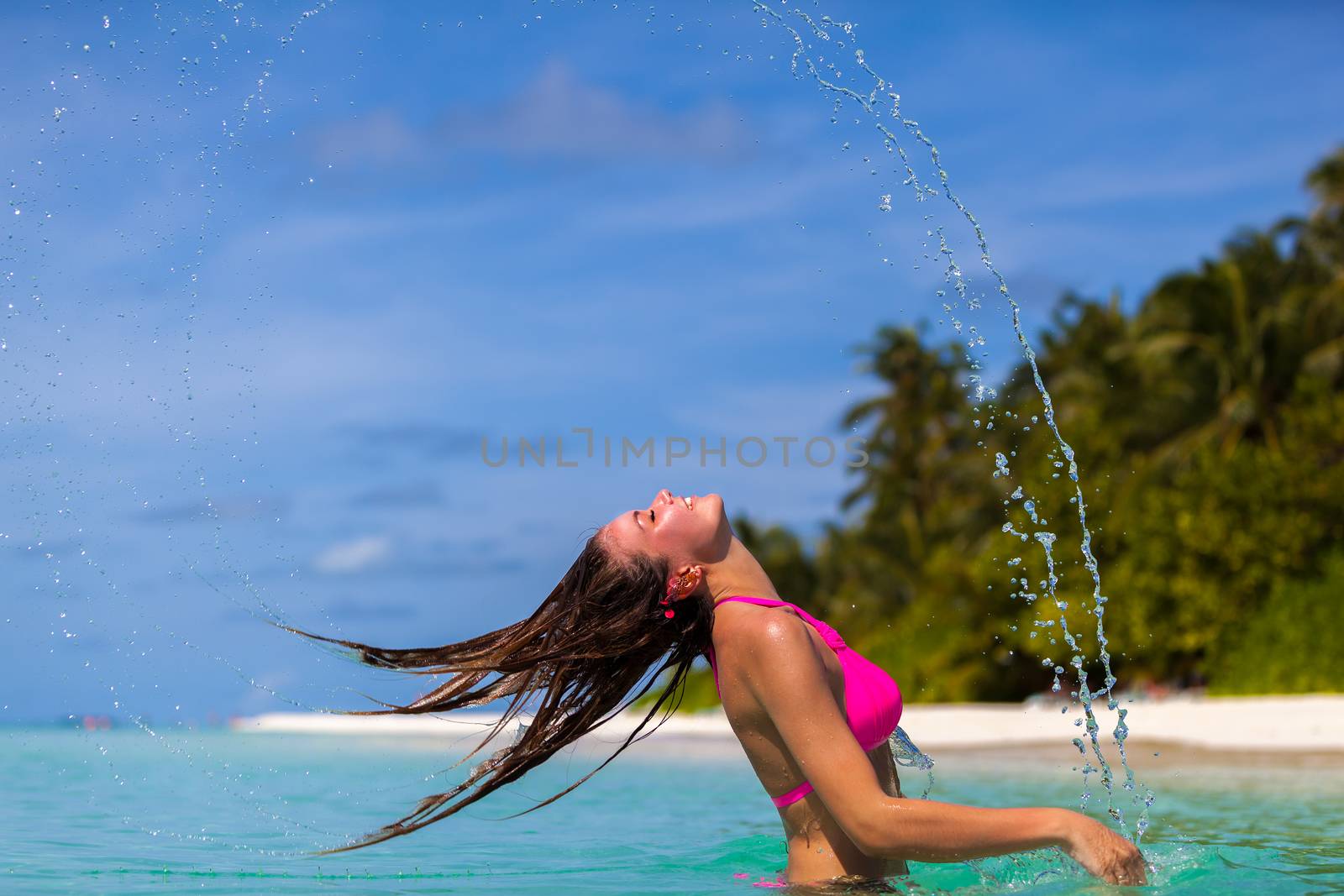 Maldives, a young woman throwing back her hair by 25ehaag6