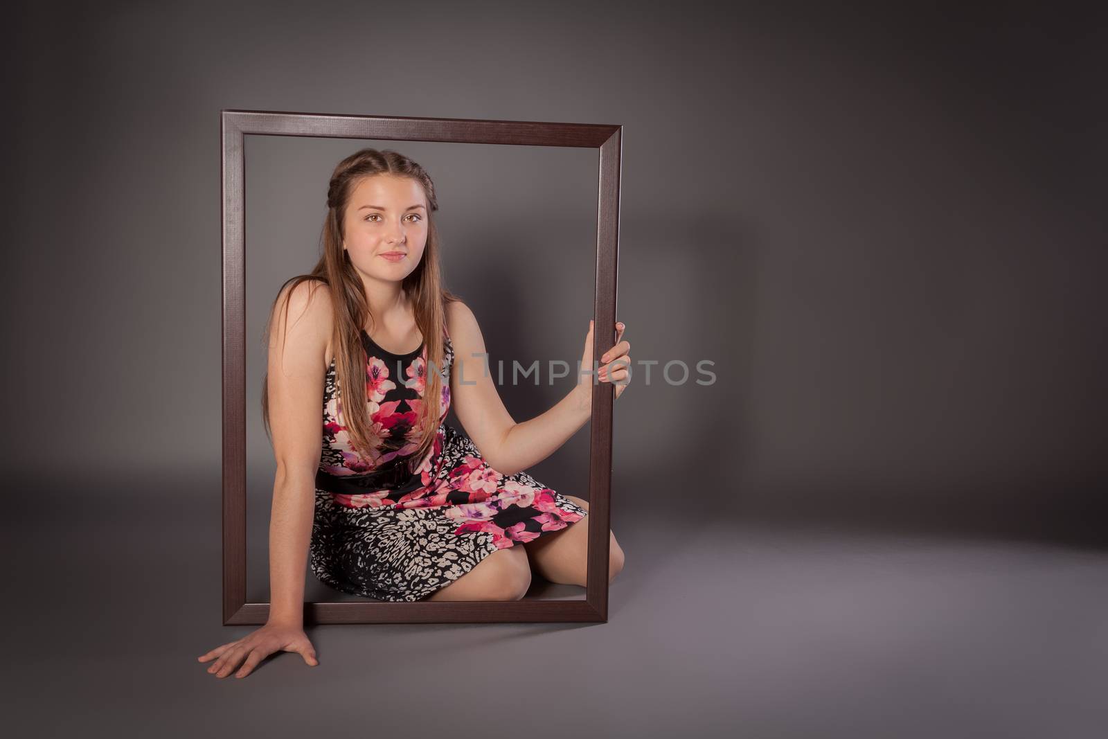 Young woman is sitting on floor with a picture frame by 25ehaag6
