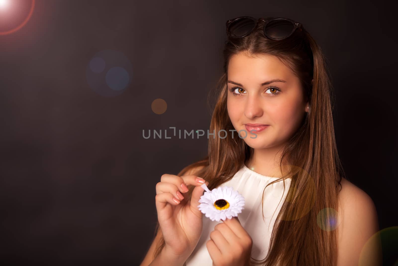 Young girl with a flower and sun glasses