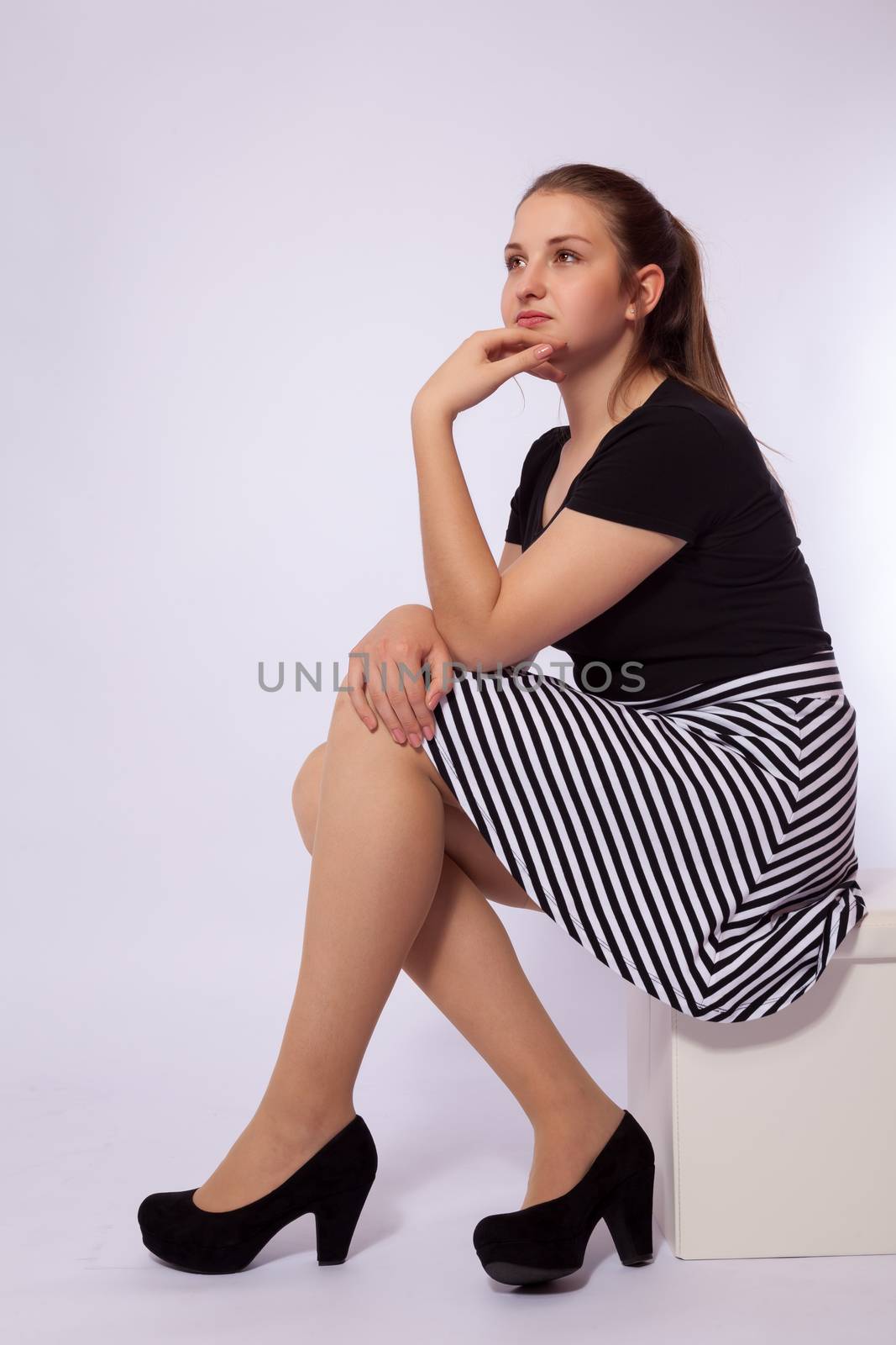 A young girl is sitting on a stool