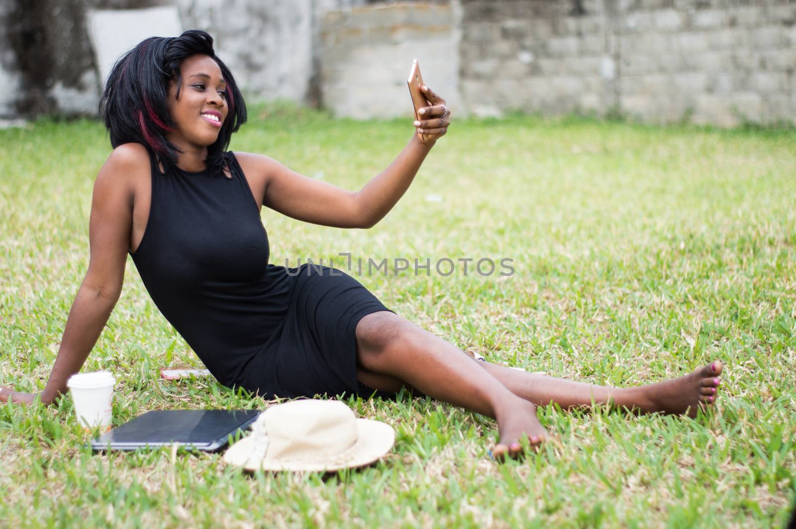 girl sitting alone at the park takes a picture in the park with a smatphone