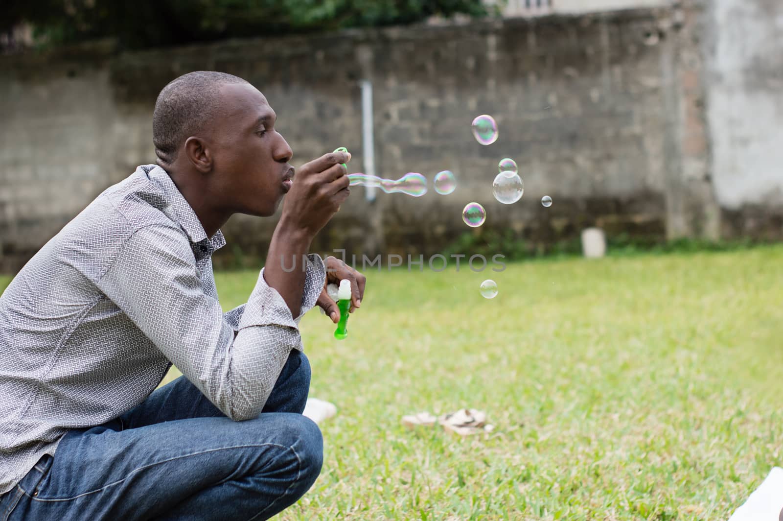 Happy man at the park playing with soap bubbles