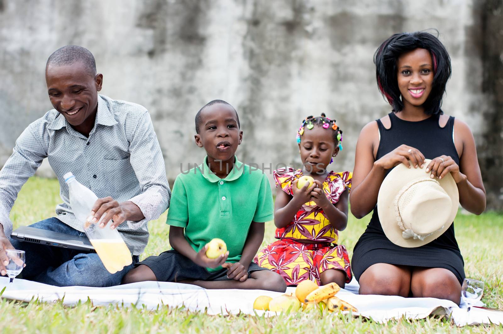 happy family sitting outdoors picnicking and playing together