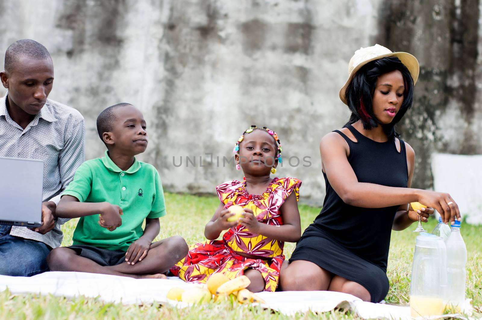 happy family sitting outdoors picnicking and playing together