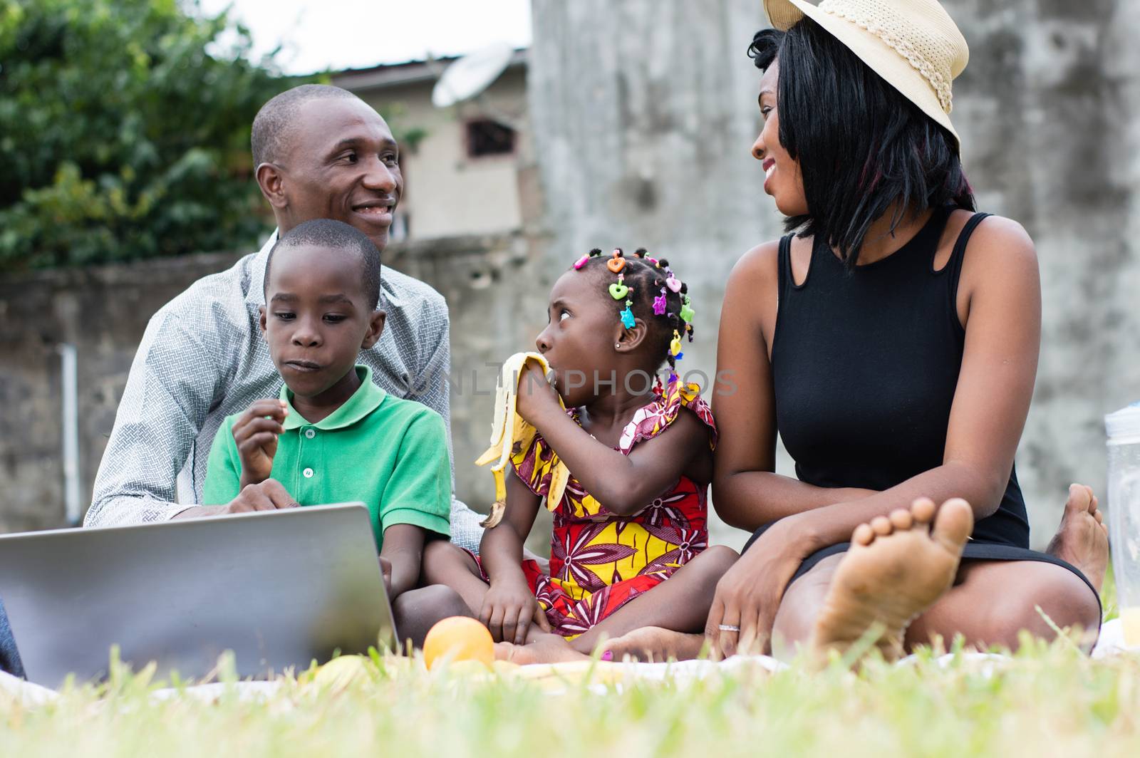 modern and happy family sitting at the park sharing a lunch and playing together