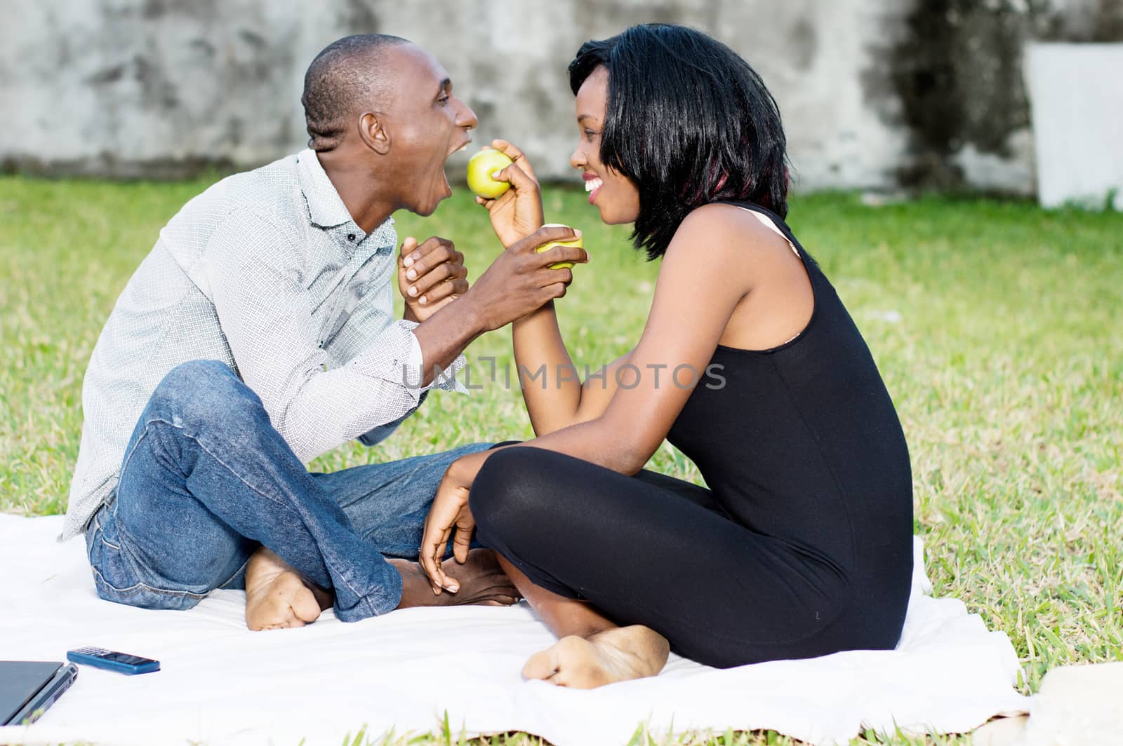 young couple picnicking at the park by vystek