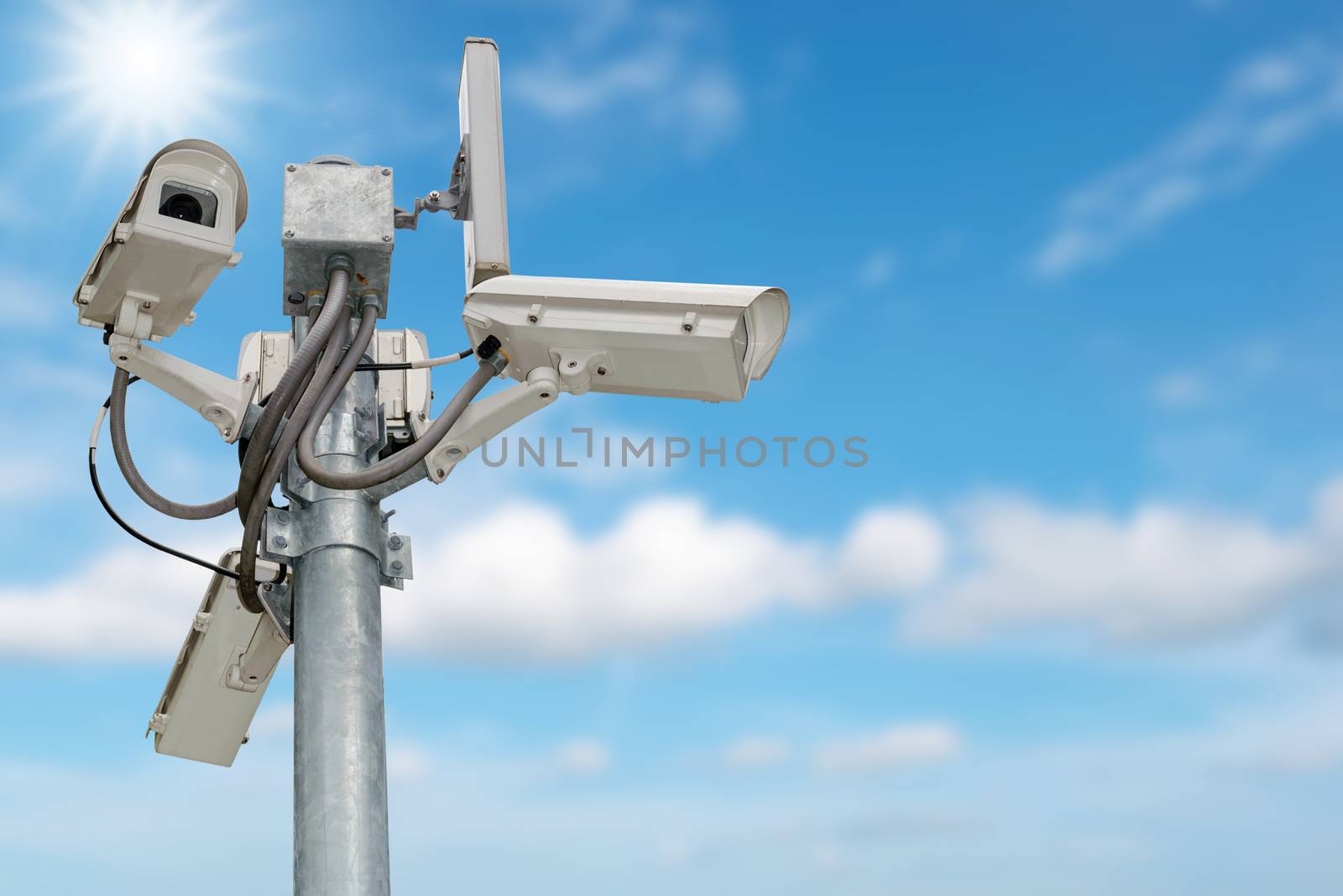 Group of security cameras (CCTV) or surveillance camera on pole isolated on blue sky background.